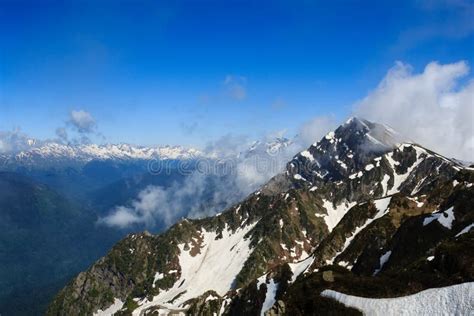High Rocky Mountain Peak With Snow And Clouds In Caucasus Stock Image
