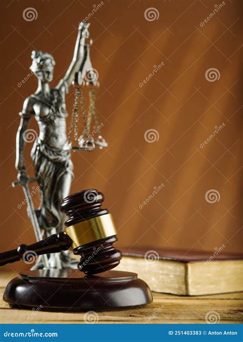 Symbols of Justice - a Wooden Gavel of a Judge, a Figurine of Themis