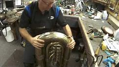 Brass instrument dent removal techniques. Tuba dents removed in bow