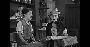 Charlie Chaplin, store clerk, helps forgetful customer (Edna Purviance)