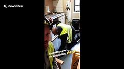 Plumber attempts to defrost freezer with screwdriver much to the disapproval of his colleague