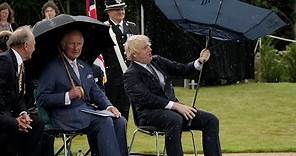 Boris Johnson struggles with umbrella at police memorial unveiling