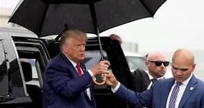 Walt Nauta holds umbrella for Trump after arraignment