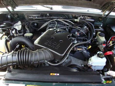 Mechanic performing engine maintenance on a '02 Ford Explorer Sport Trac