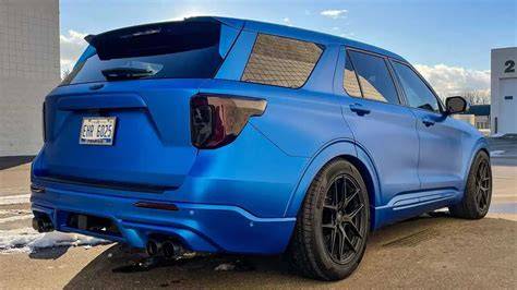A sleek, custom Ford Explorer ST in a striking color, showcasing aftermarket wheels and aerodynamic enhancements.