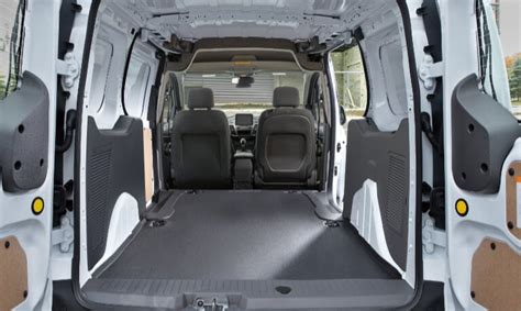 Interior view of a customized Ford E-Transit cargo van with shelving and workbenches installed