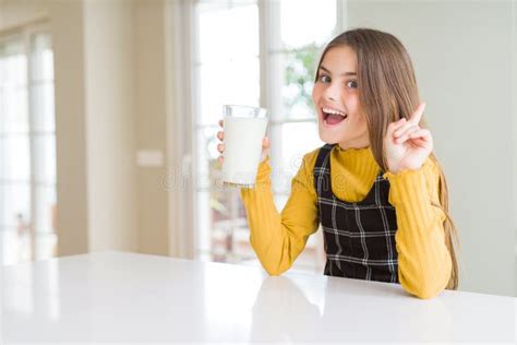 girl smiling while holding a drinking glass